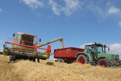 Symobl Mahdrescher und Traktor auf Feld